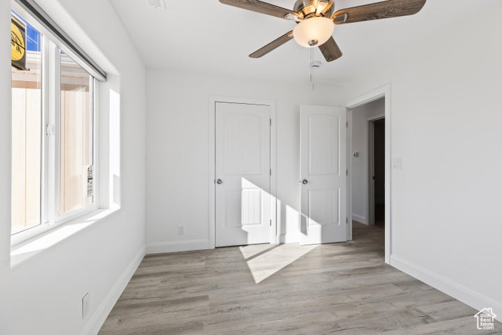 Unfurnished bedroom with baseboards, light wood finished floors, and ceiling fan