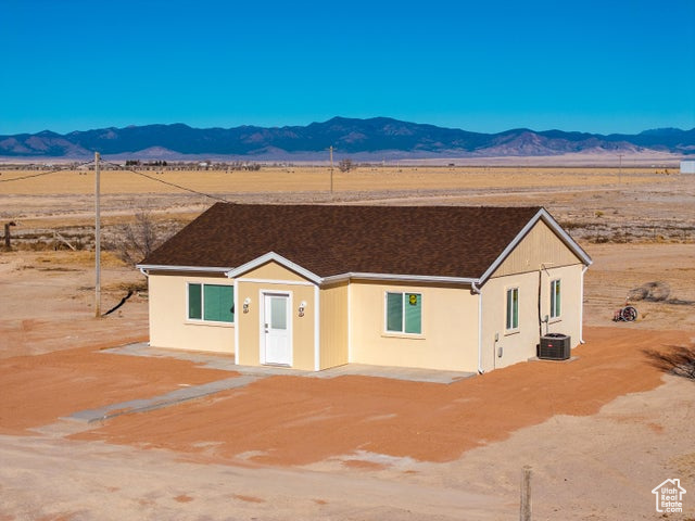 View of front of property with a mountain view, view of desert, and a view of rural / pastoral area