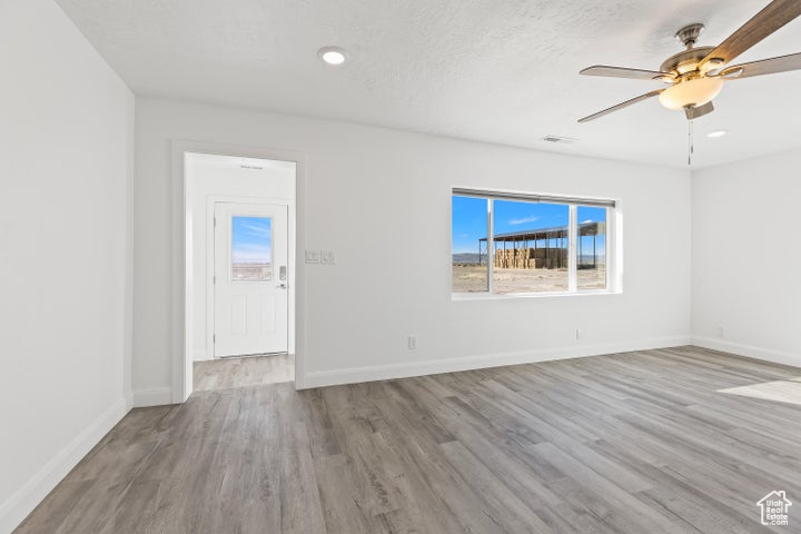 Spare room with wood finished floors, baseboards, a ceiling fan, and recessed lighting
