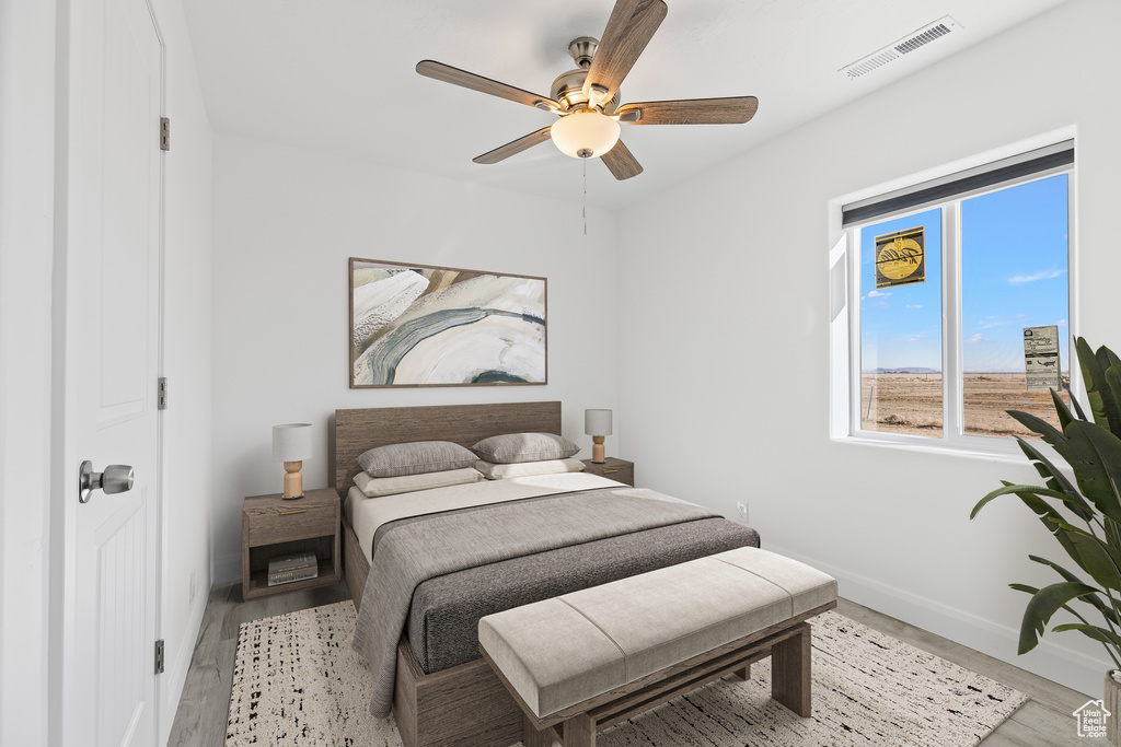 Bedroom featuring baseboards, wood finished floors, and ceiling fan