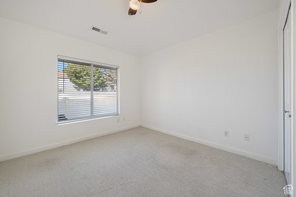 Carpeted spare room with ceiling fan