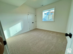Unfurnished bedroom with light colored carpet