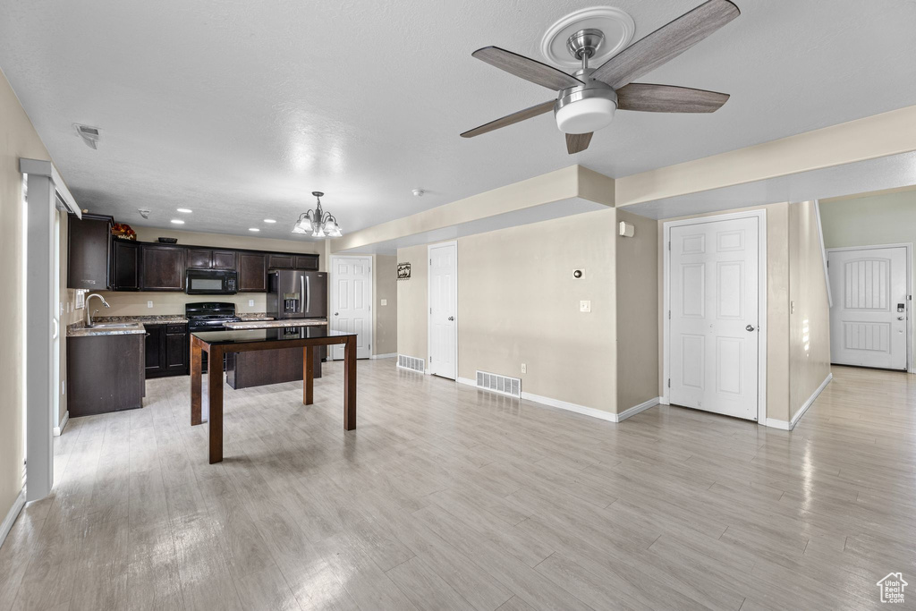 Rec room with ceiling fan with notable chandelier, sink, and light wood-type flooring