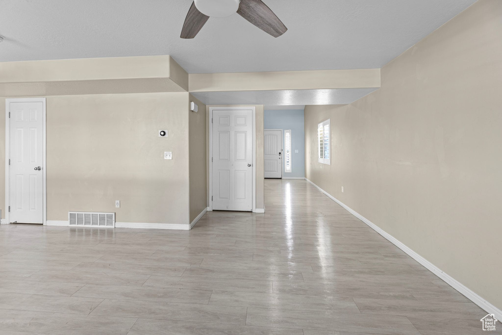 Empty room featuring light wood-type flooring and ceiling fan