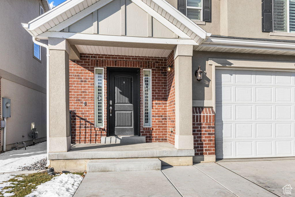 Property entrance with a garage and a porch