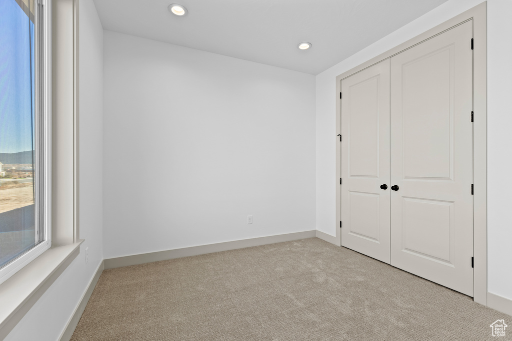 Unfurnished bedroom with a closet and light carpet