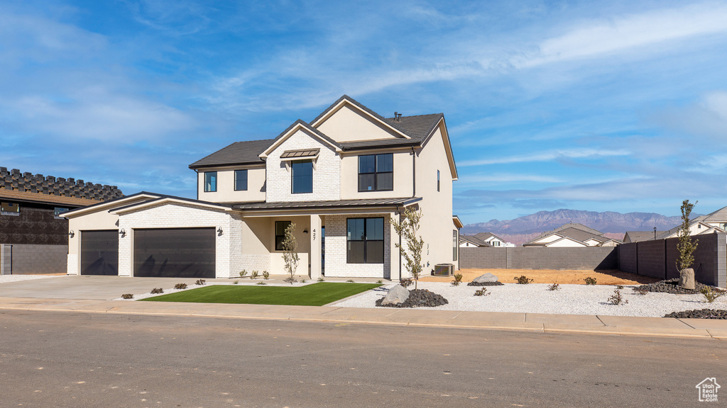 View of front of home with a garage and a mountain view