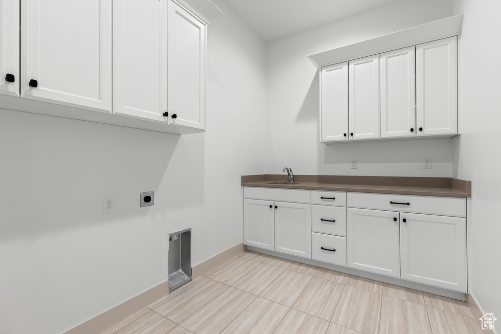 Laundry room with cabinets, electric dryer hookup, and sink