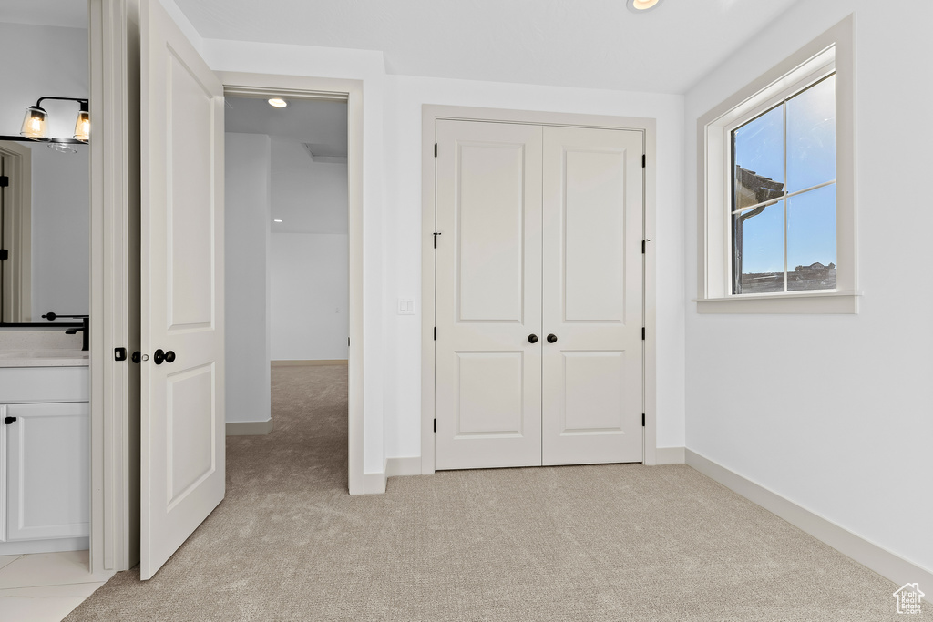 Unfurnished bedroom with a closet and light carpet