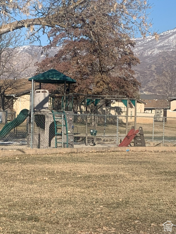 View of play area with a mountain view and a yard