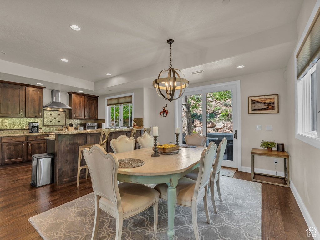 Dining area featuring dark wood-style flooring, a chandelier, recessed lighting, and baseboards