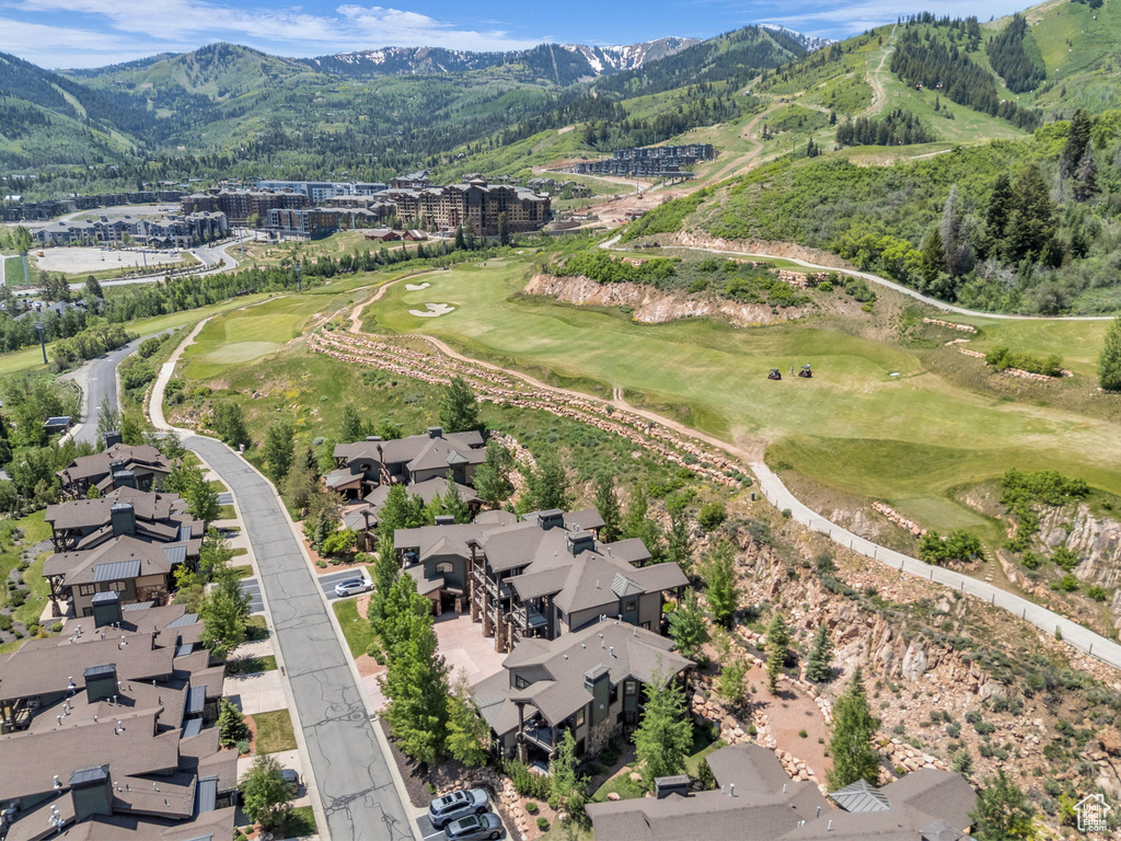 Aerial overview of property's location featuring a mountain backdrop, a local golf course, and nearby suburban area