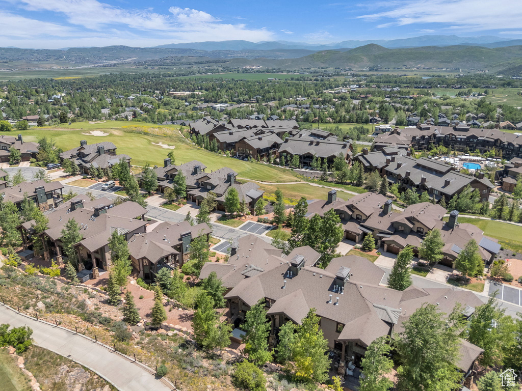 Aerial view of property's location with mountains, nearby suburban area, and a golf course