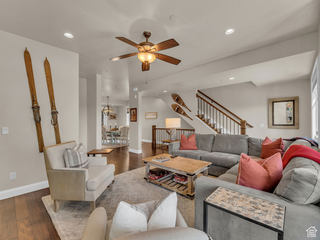 Living room with ceiling fan, baseboards, dark wood finished floors, stairs, and recessed lighting
