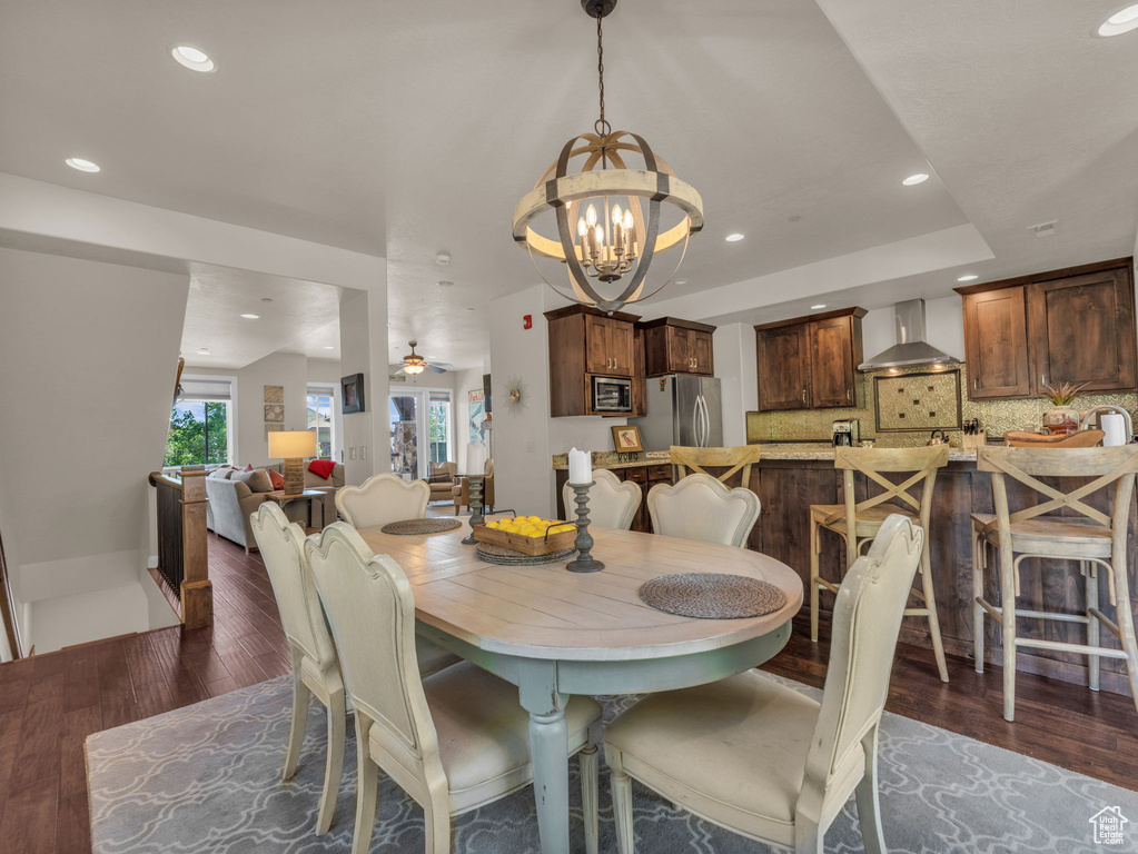 Dining area with a chandelier, wood finished floors, and recessed lighting