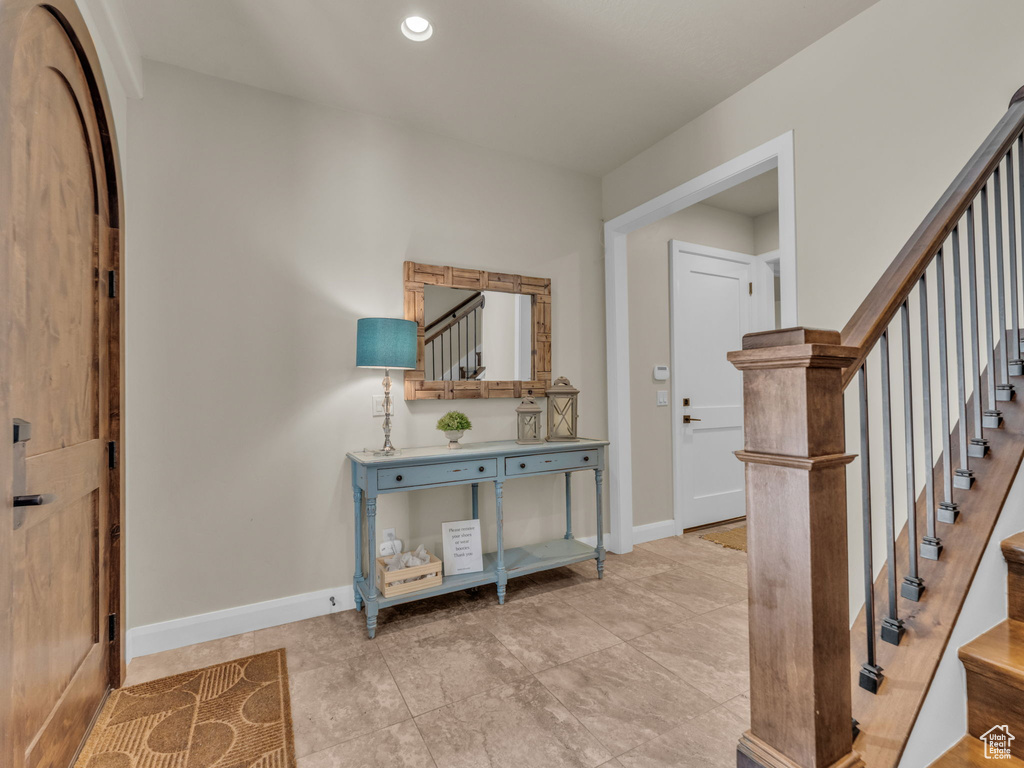 Foyer entrance with stairs and baseboards