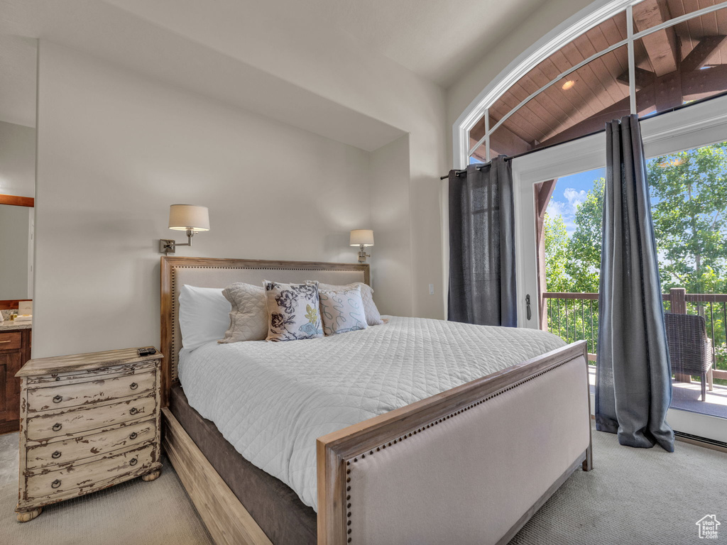 Carpeted bedroom featuring access to exterior and vaulted ceiling
