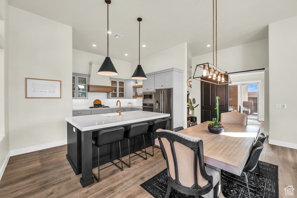 Dining area featuring sink, hardwood / wood-style flooring, and a high ceiling