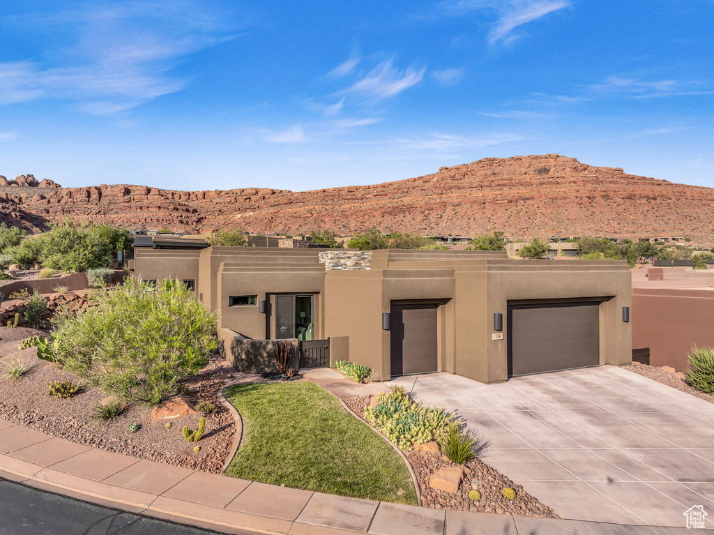 Adobe home with a garage and a mountain view