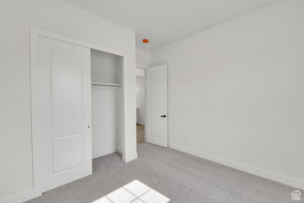Unfurnished bedroom with carpet and a closet