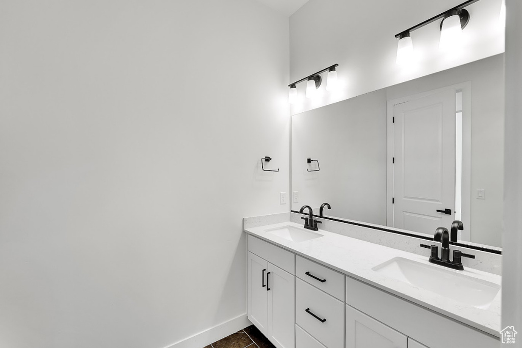 Bathroom with double vanity and tile patterned flooring