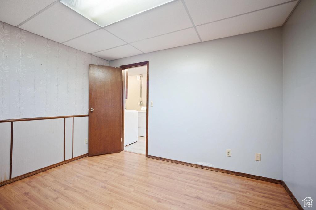 Spare room with a drop ceiling and light hardwood / wood-style flooring