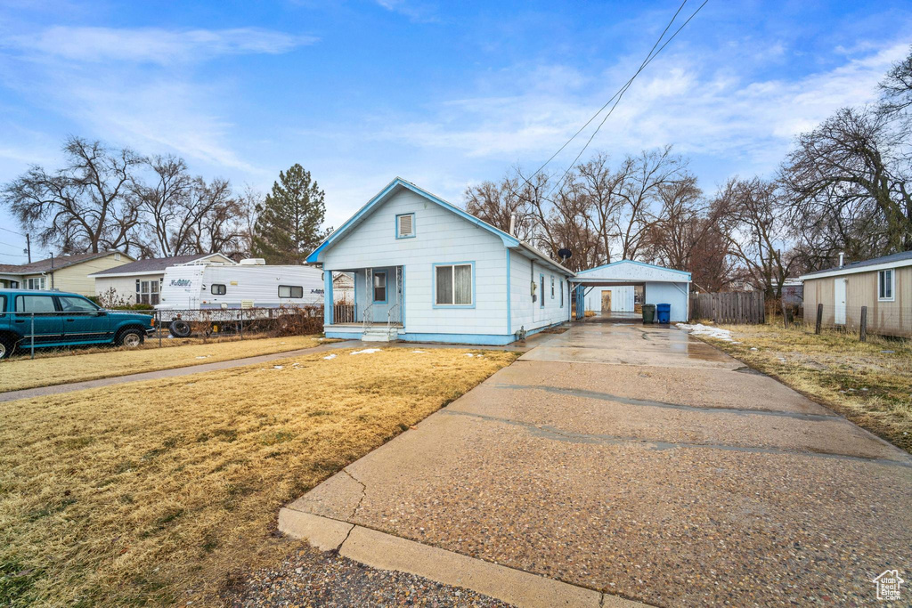 Bungalow-style house with a garage, a front lawn, and a porch