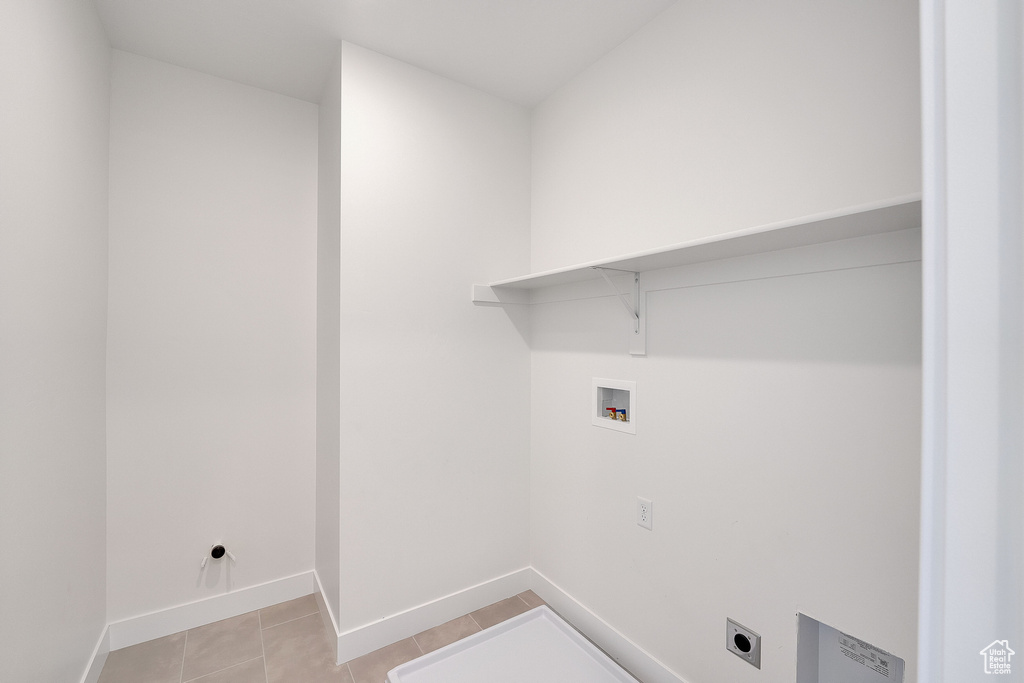 Clothes washing area with washer hookup, electric dryer hookup, baseboards, and light tile patterned floors