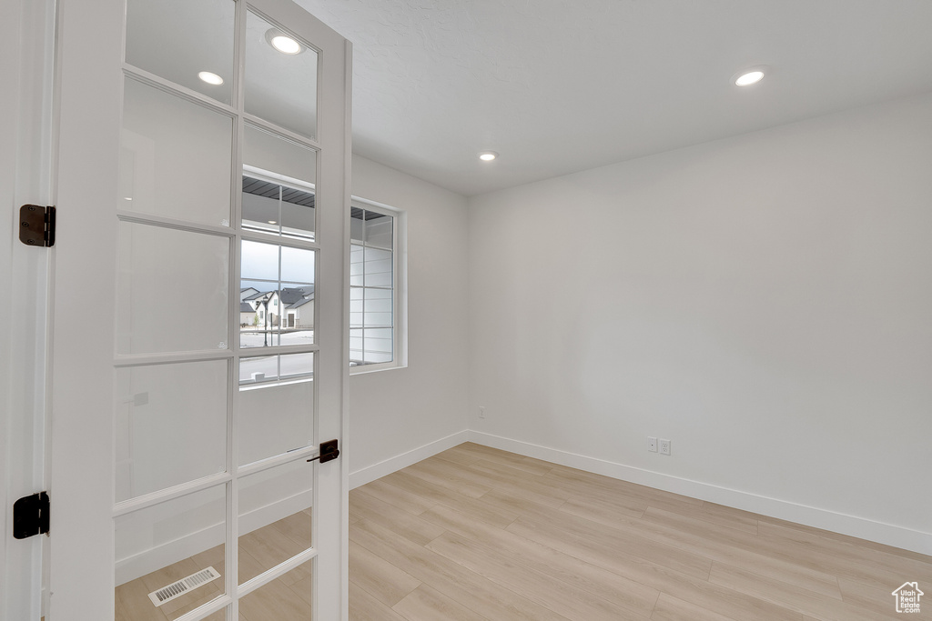 Spare room with light wood-style flooring, baseboards, and recessed lighting
