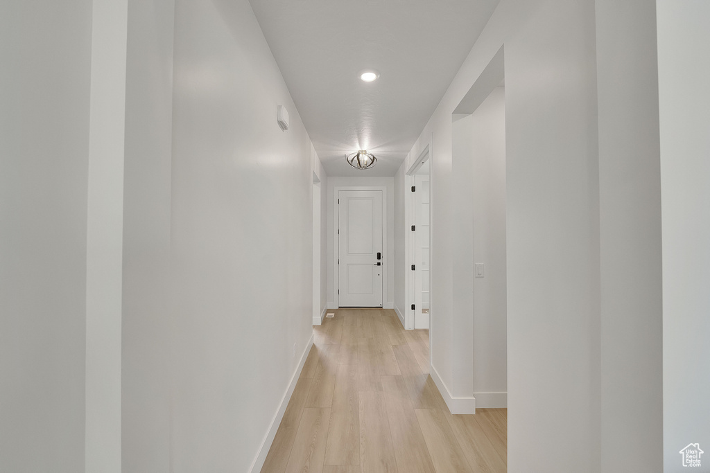 Corridor with baseboards, light wood-style floors, and recessed lighting