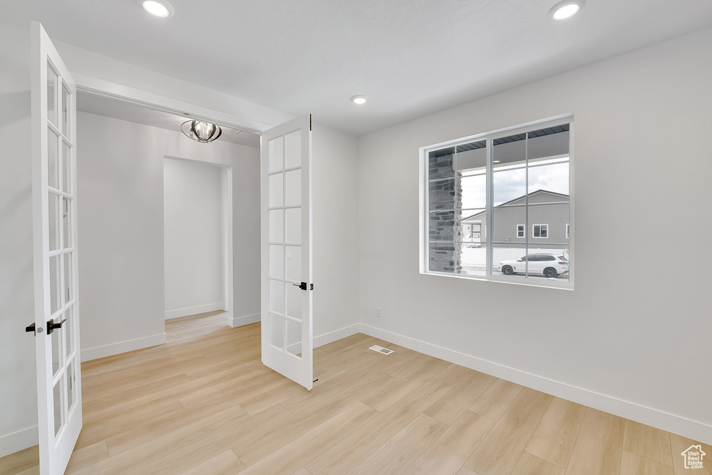 Unfurnished room with french doors, baseboards, wood finished floors, and recessed lighting