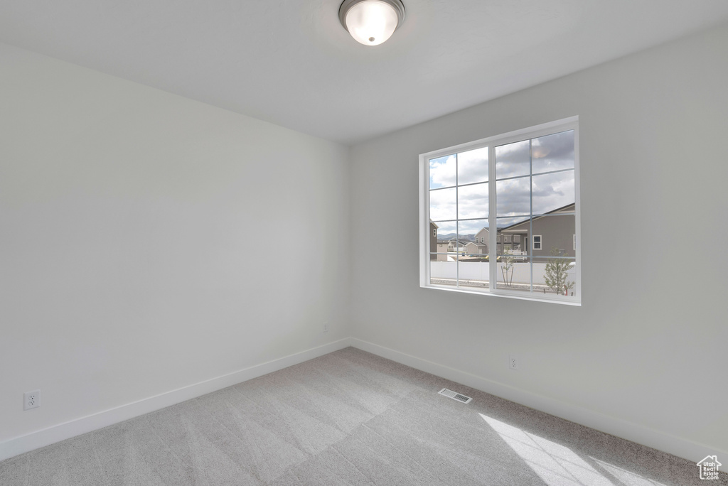 Carpeted empty room with baseboards