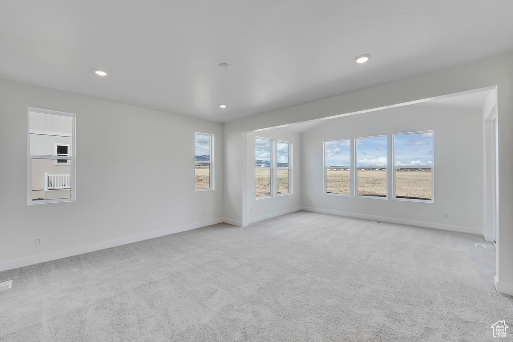 Spare room featuring light colored carpet, baseboards, and recessed lighting