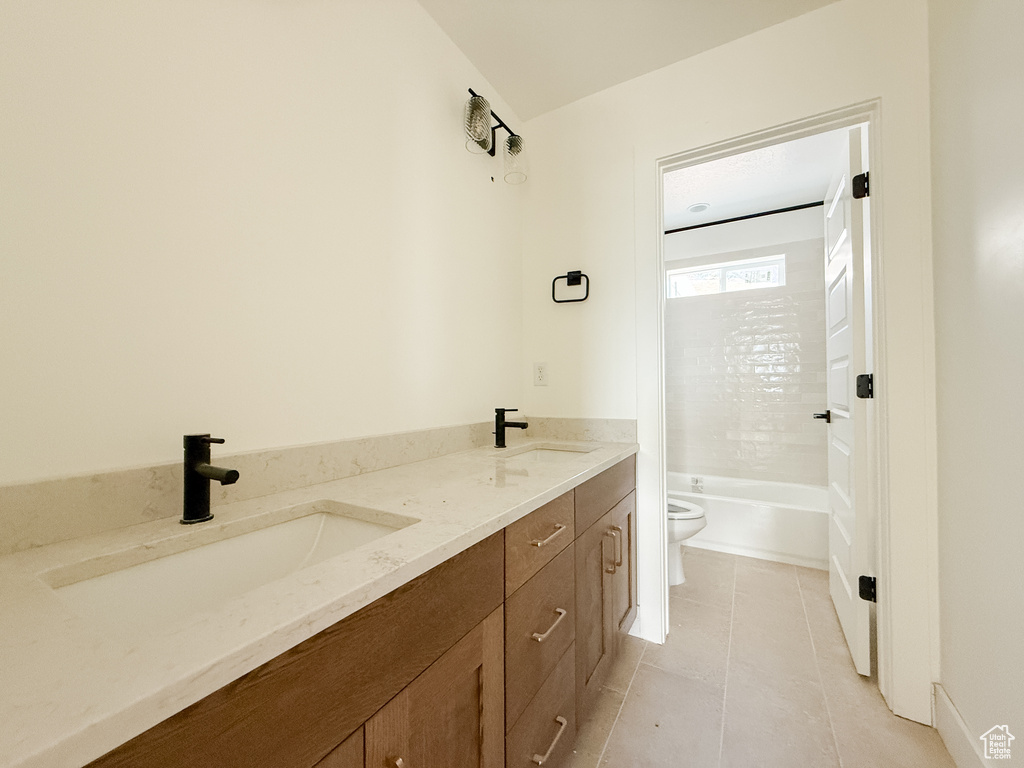 Full bath with double vanity and tile patterned flooring