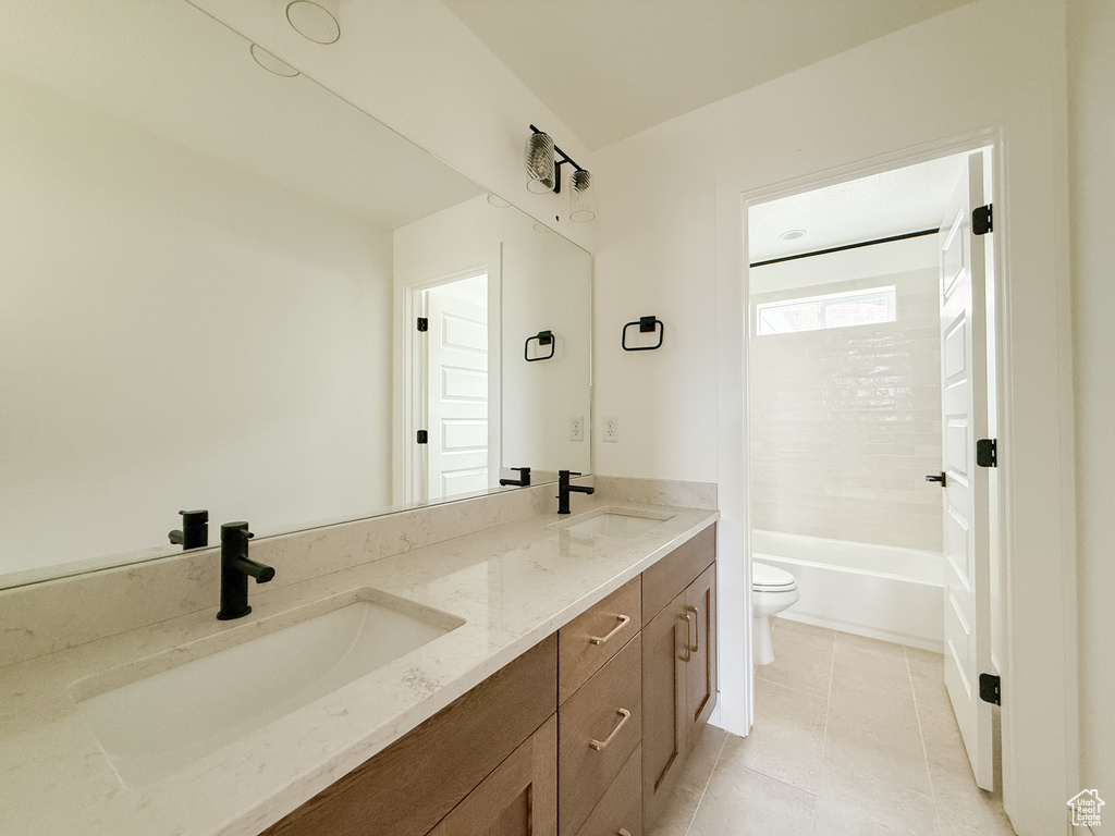 Full bathroom with double vanity, tile patterned flooring, and  shower combination