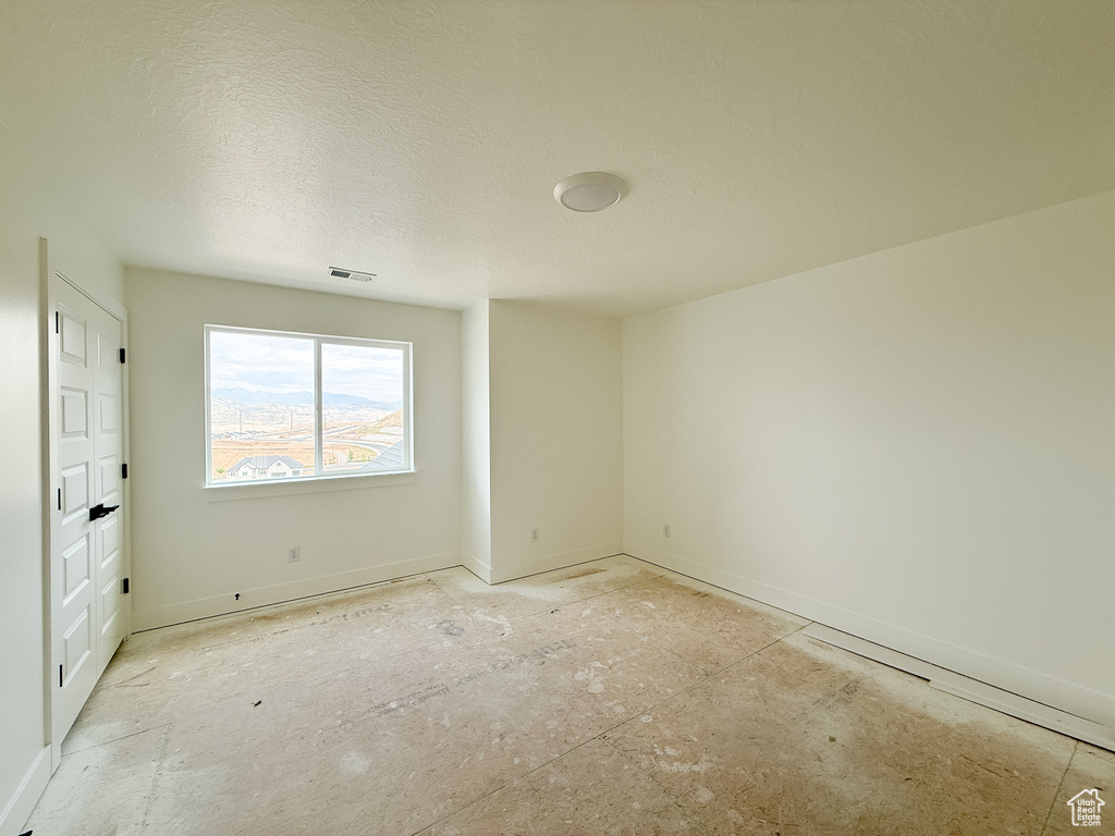 Spare room featuring baseboards and a textured ceiling