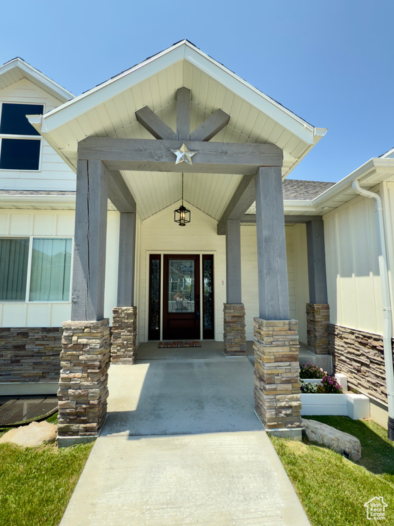 Property entrance with stone siding and a porch