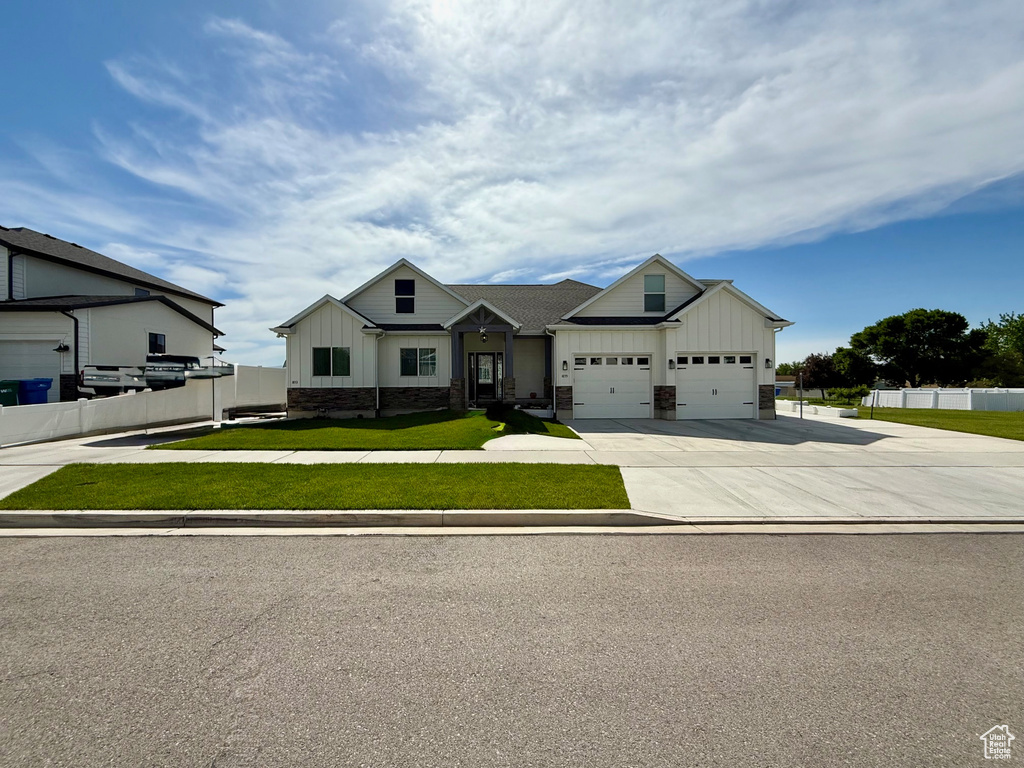 Modern inspired farmhouse with board and batten siding, an attached garage, and driveway