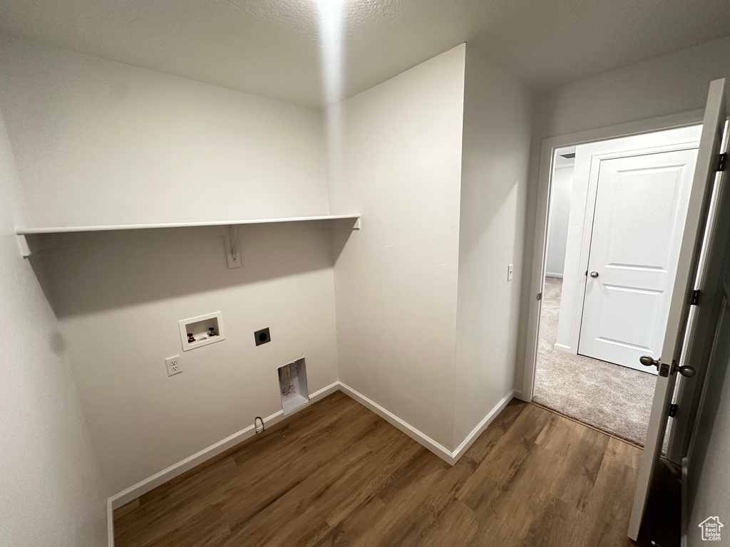 Clothes washing area with gas dryer hookup, hookup for a washing machine, dark hardwood / wood-style floors, and hookup for an electric dryer