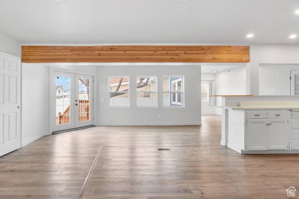 Unfurnished living room with french doors and light wood-type flooring