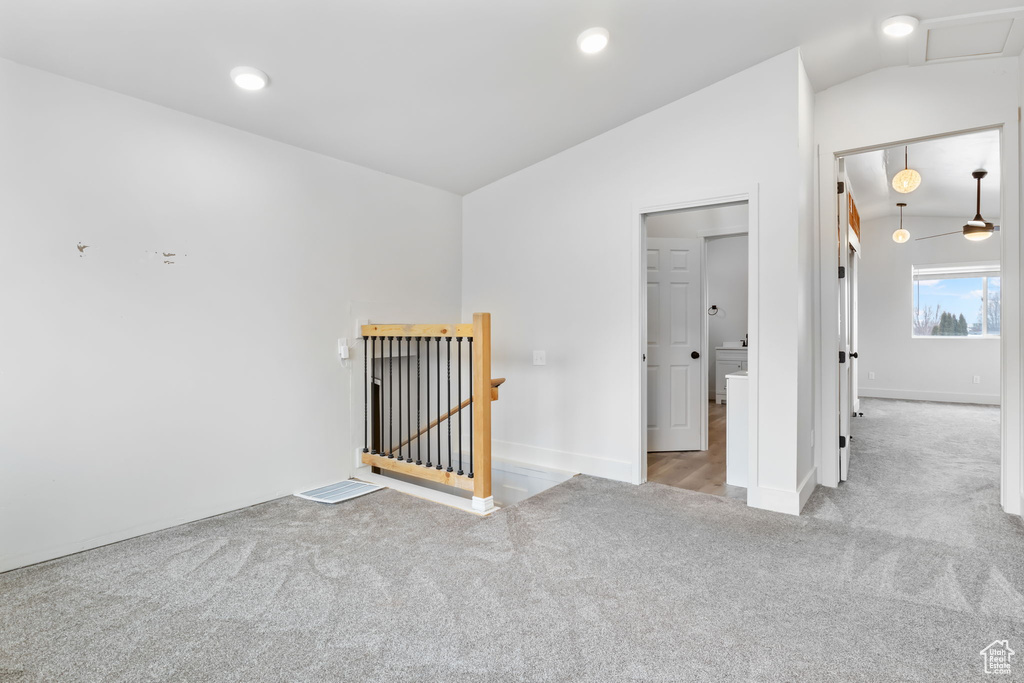 Carpeted spare room with vaulted ceiling