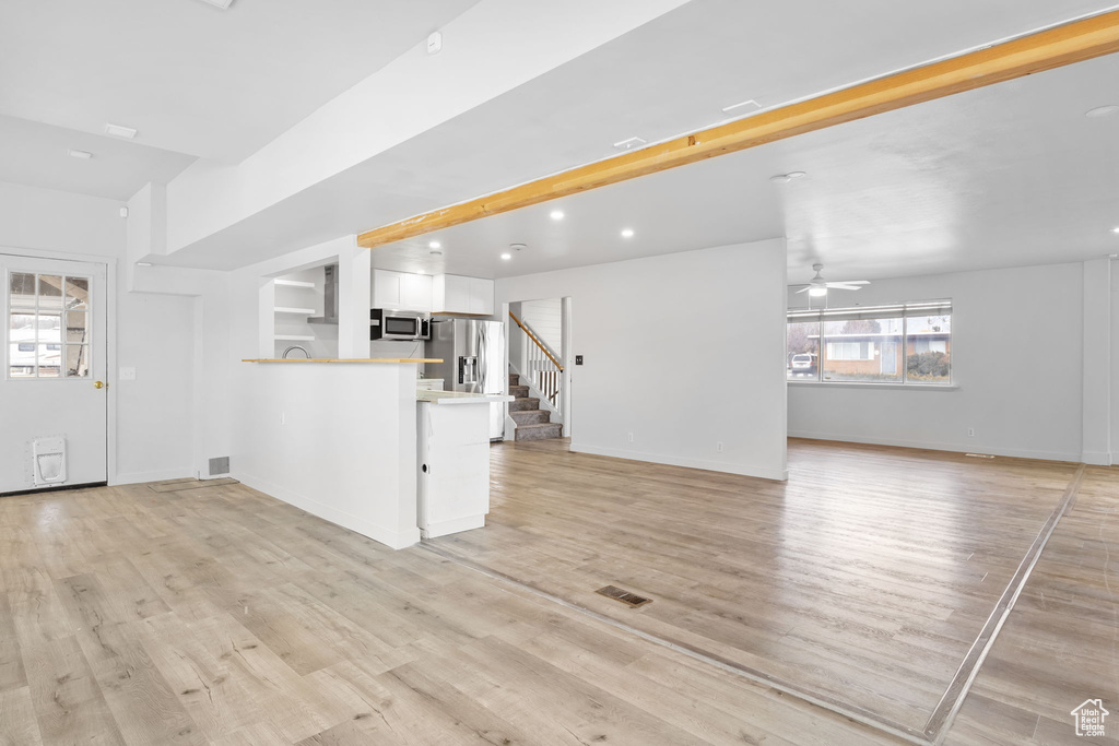 Unfurnished living room featuring light hardwood / wood-style flooring and ceiling fan