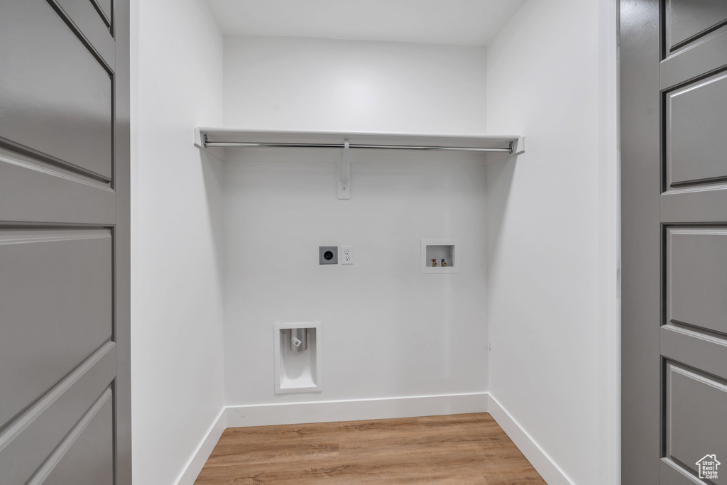 Laundry area with light hardwood / wood-style flooring, washer hookup, and hookup for an electric dryer