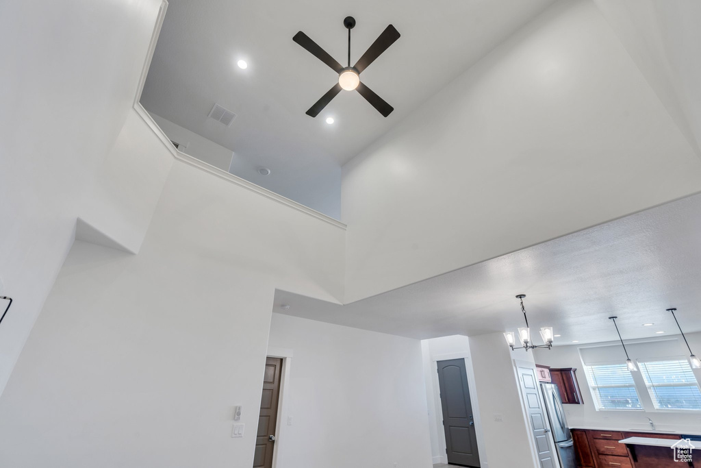Interior details with ceiling fan with notable chandelier and stainless steel fridge