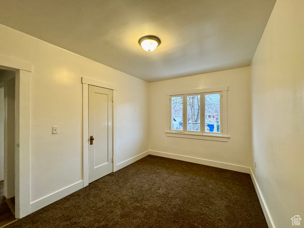 Unfurnished room with dark colored carpet