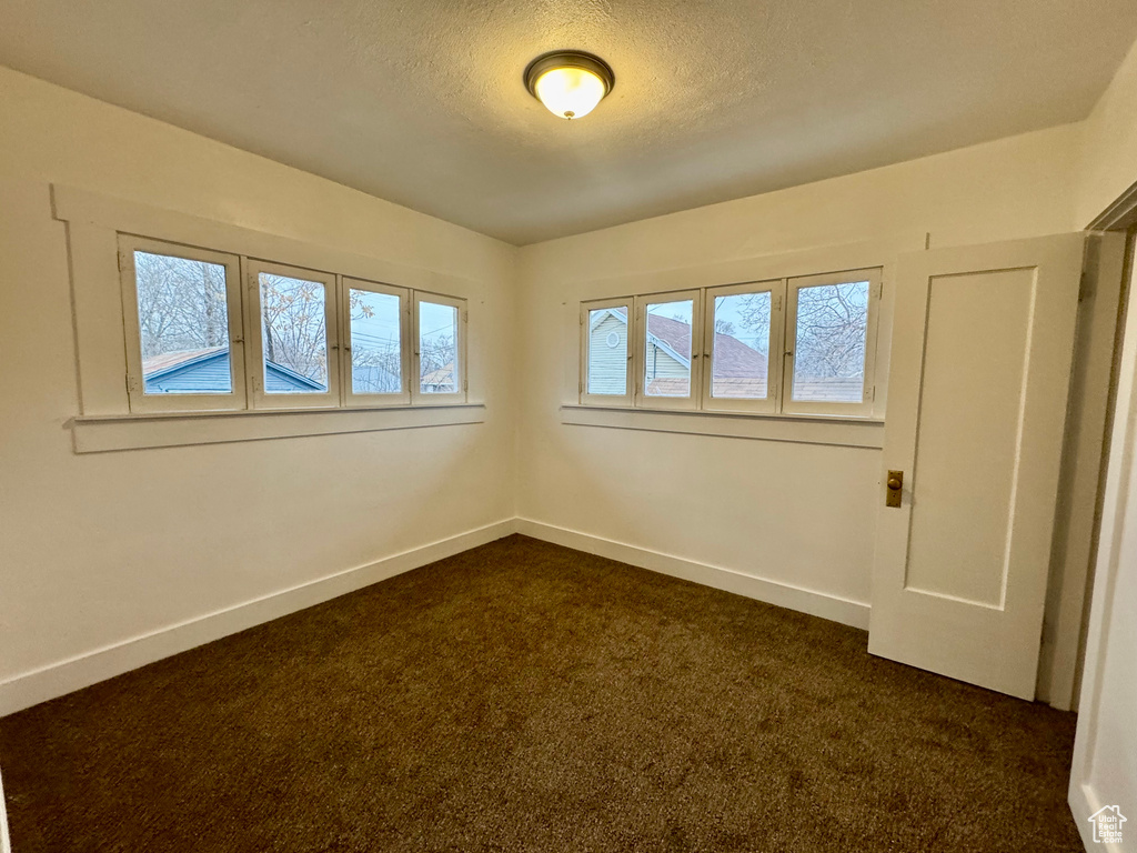 Carpeted spare room featuring a textured ceiling