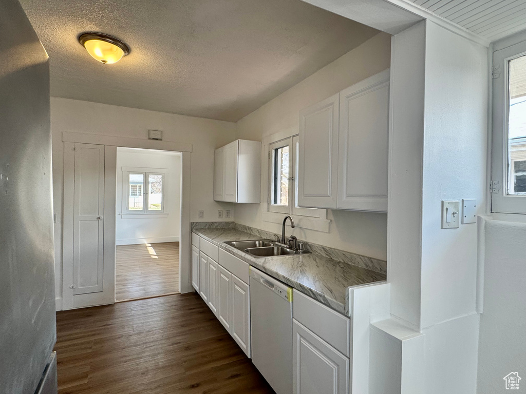 Kitchen with white cabinetry, dark wood-style flooring, a sink, a textured ceiling, and dishwasher