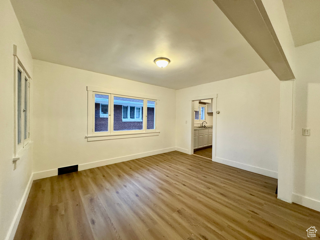 Unfurnished room with sink, a wealth of natural light, and light hardwood / wood-style flooring