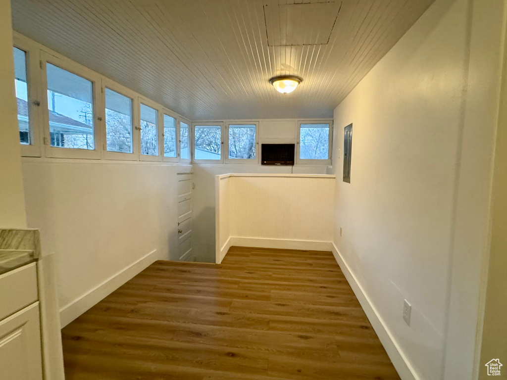 Corridor with wood-type flooring, electric panel, and wooden ceiling