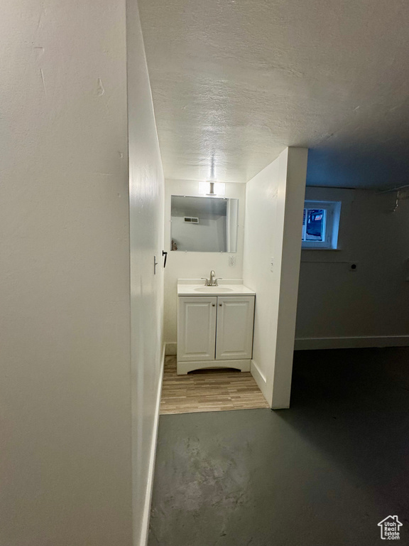 Bathroom with hardwood / wood-style flooring, vanity, and a textured ceiling